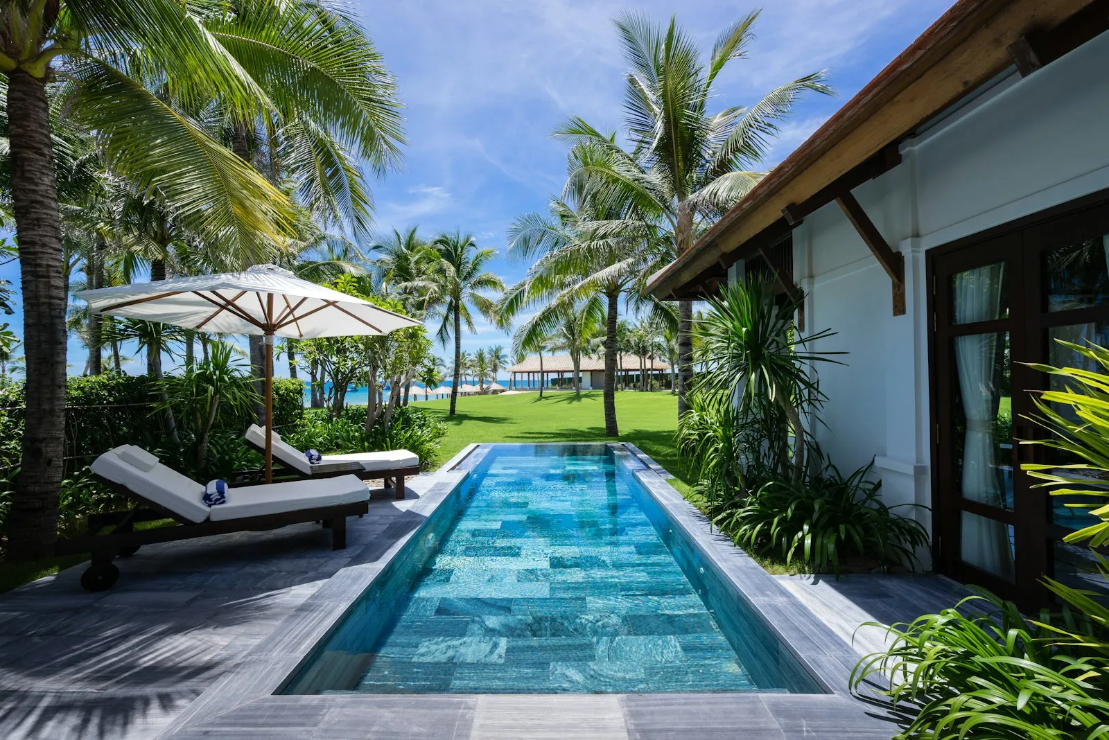 A tropical villa with a private pool and loungers